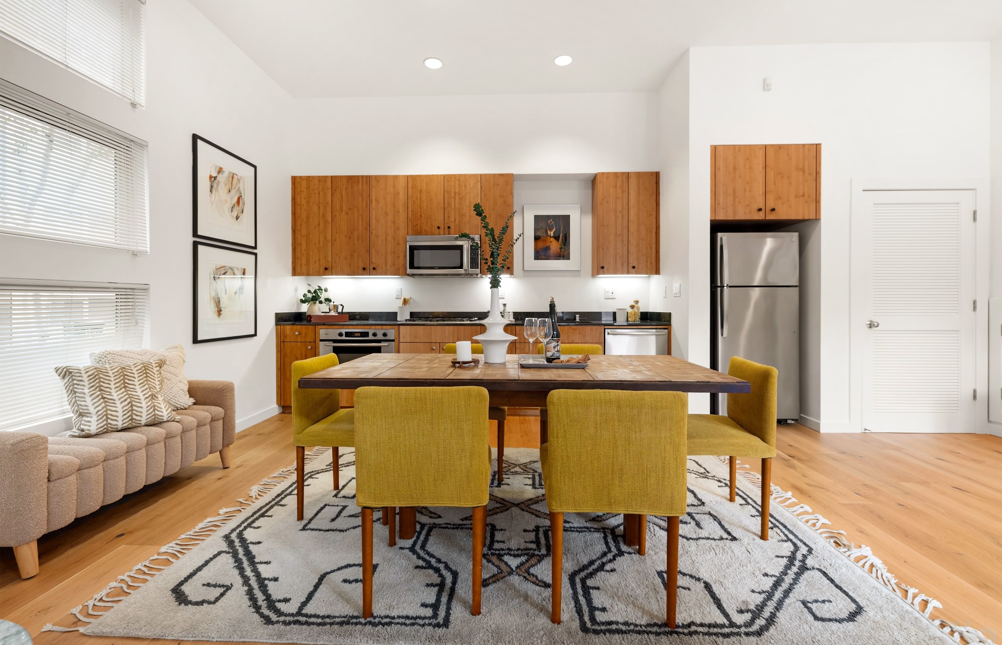 Dining and kitchen with warm cabinetry